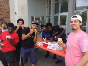 Members of Young Men of Color eating breakfast before the Block Party.